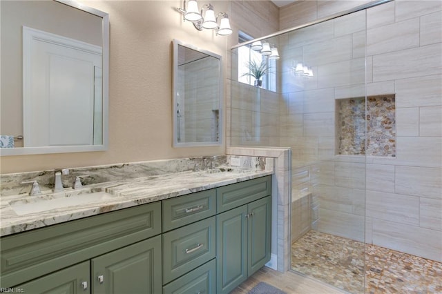 bathroom with tiled shower, hardwood / wood-style floors, and vanity