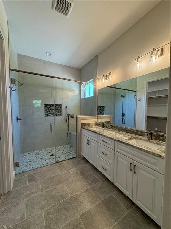 bathroom with a shower with door and vanity