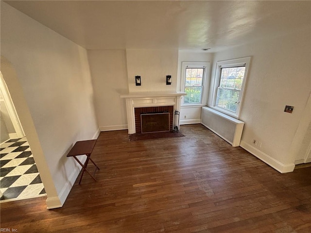 unfurnished living room with a fireplace and dark hardwood / wood-style floors