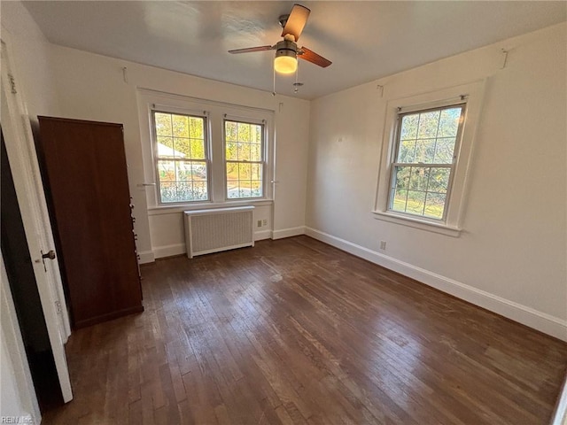 unfurnished bedroom featuring radiator, ceiling fan, and dark hardwood / wood-style floors