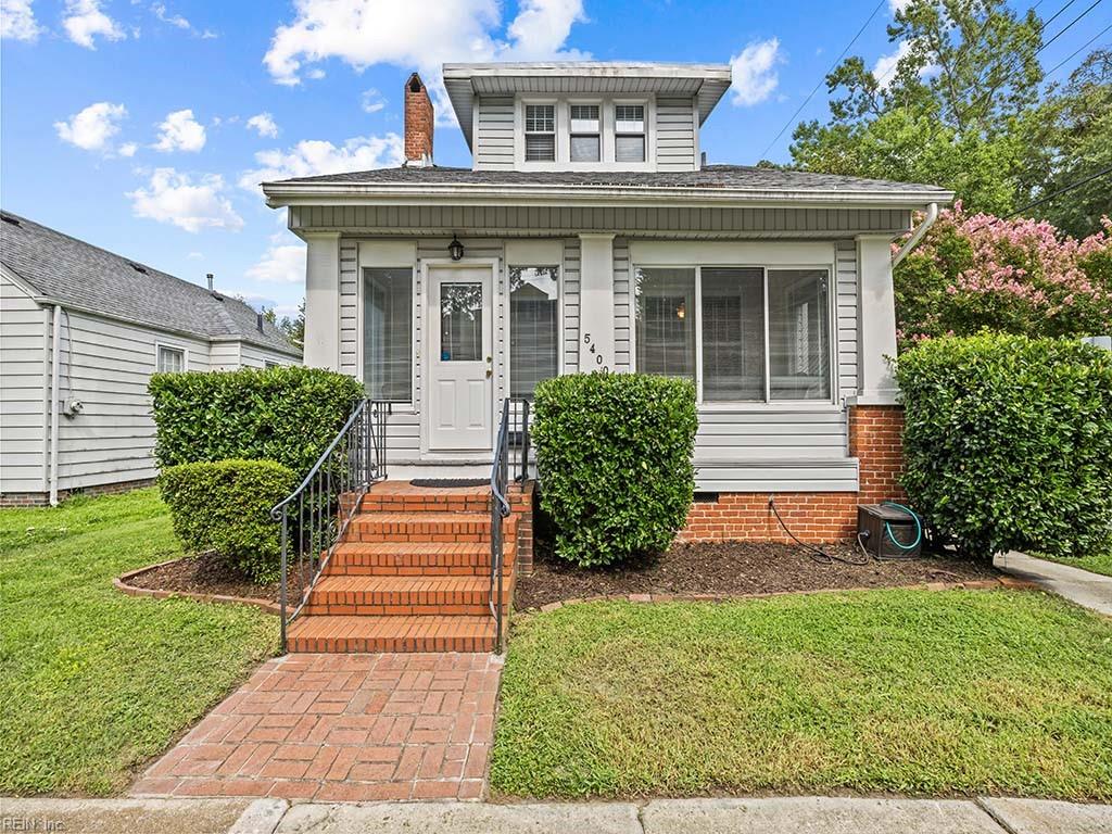 bungalow-style home with a front yard