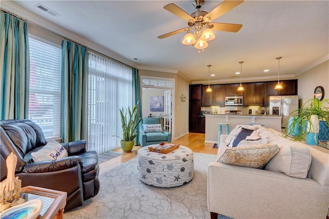 living room featuring ceiling fan, light hardwood / wood-style floors, and ornamental molding