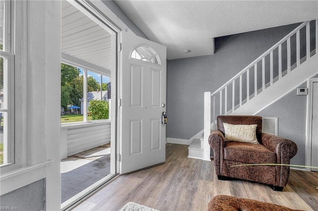 foyer entrance featuring light hardwood / wood-style floors and a textured ceiling