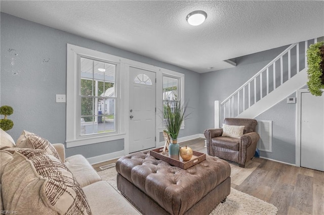 living room featuring light hardwood / wood-style floors and a textured ceiling