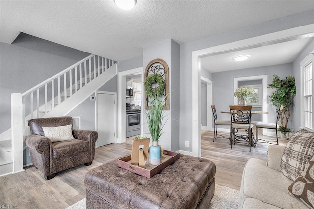 living room with a textured ceiling and light hardwood / wood-style flooring