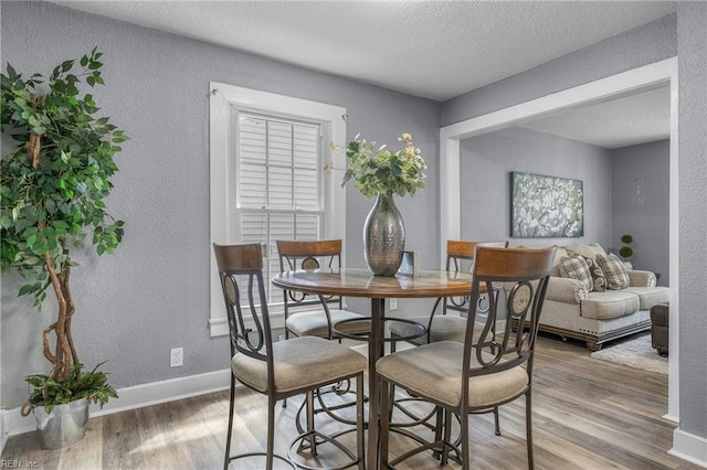 dining area with a textured ceiling and hardwood / wood-style flooring