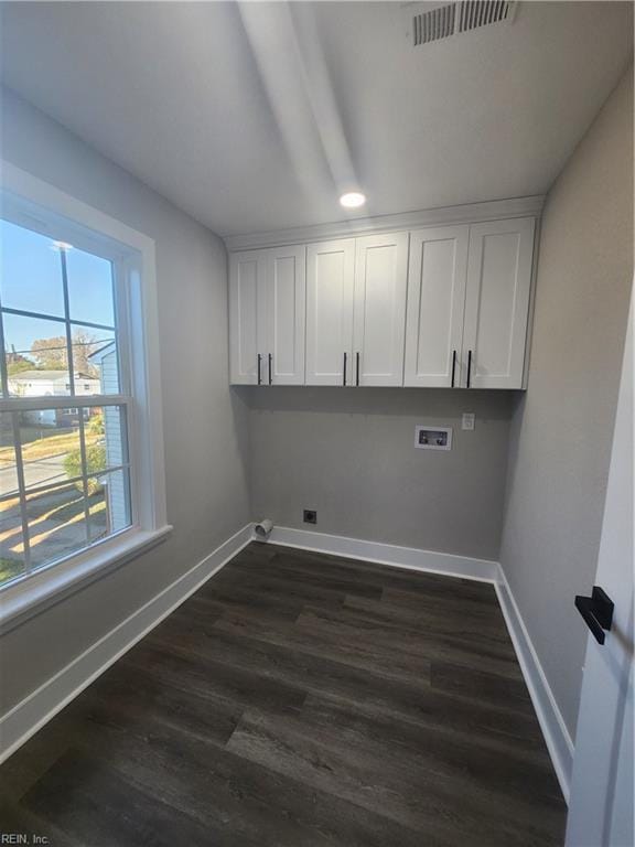 laundry area featuring cabinets, hookup for a washing machine, and dark hardwood / wood-style flooring