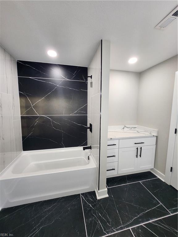 bathroom with vanity and tiled shower / bath combo