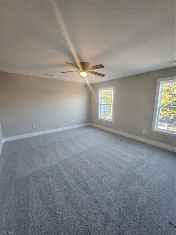 carpeted spare room featuring ceiling fan and a textured ceiling