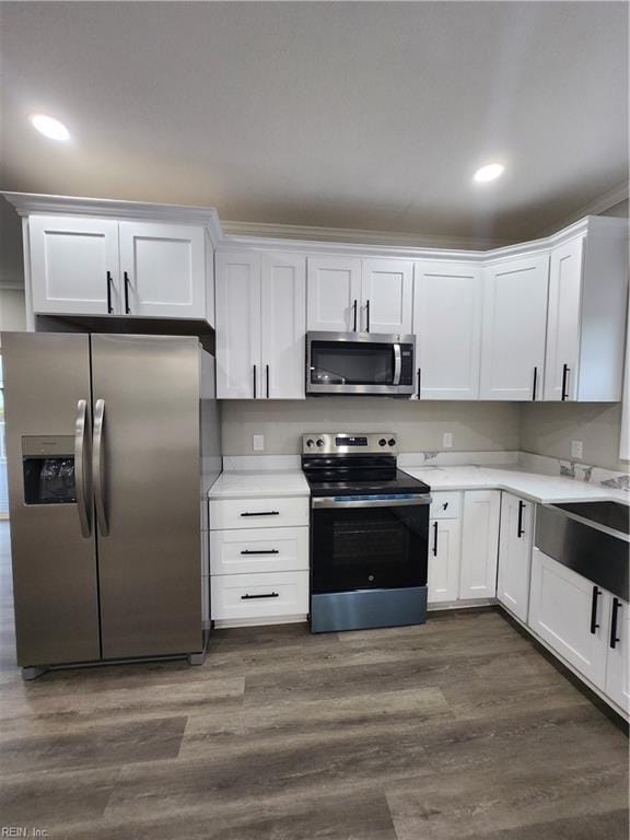 kitchen featuring dark hardwood / wood-style flooring, white cabinets, stainless steel appliances, and sink