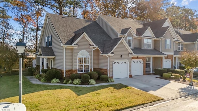 townhome / multi-family property featuring a garage and a front lawn