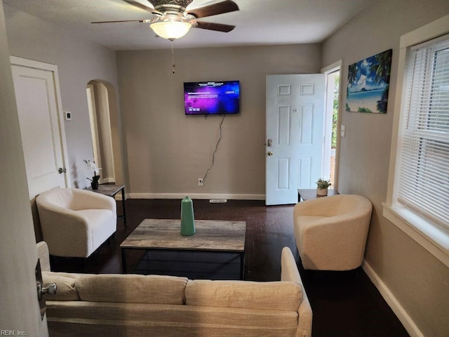 living room featuring ceiling fan and dark hardwood / wood-style floors