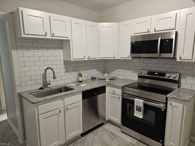 kitchen with stainless steel appliances, white cabinetry, and sink