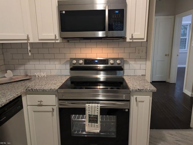 kitchen with white cabinets, light stone countertops, and appliances with stainless steel finishes