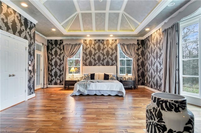 bedroom featuring a tray ceiling, crown molding, and hardwood / wood-style flooring