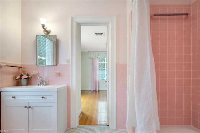 bathroom featuring a shower with curtain, vanity, hardwood / wood-style flooring, and tile walls