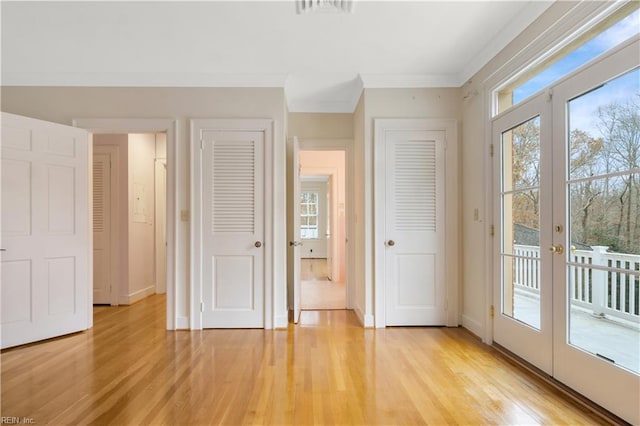 unfurnished bedroom with access to exterior, french doors, light wood-type flooring, and a closet