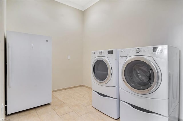 washroom with washer and clothes dryer and light tile patterned floors