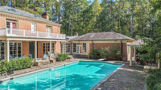 view of swimming pool with a diving board, a patio area, and french doors