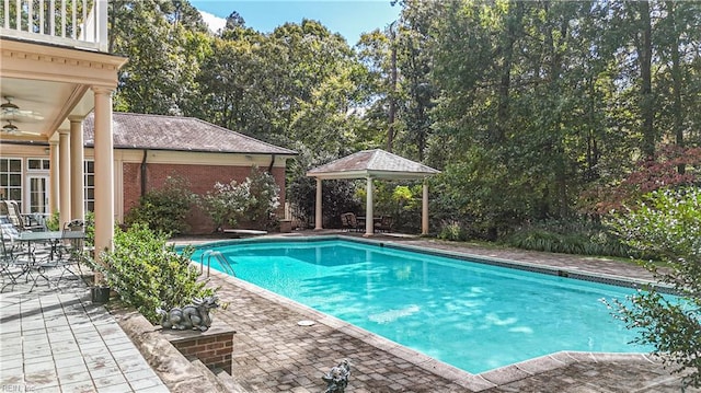 view of swimming pool featuring a patio, a diving board, and ceiling fan