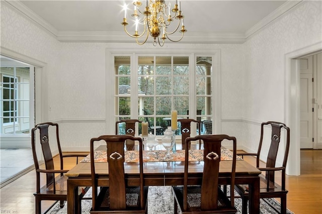 dining room featuring hardwood / wood-style flooring, ornamental molding, and an inviting chandelier