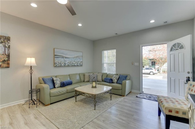 living room featuring ceiling fan and light hardwood / wood-style flooring