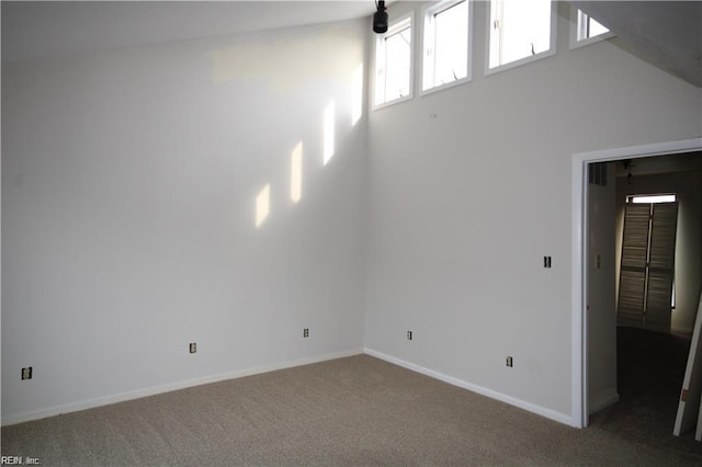 carpeted spare room with lofted ceiling