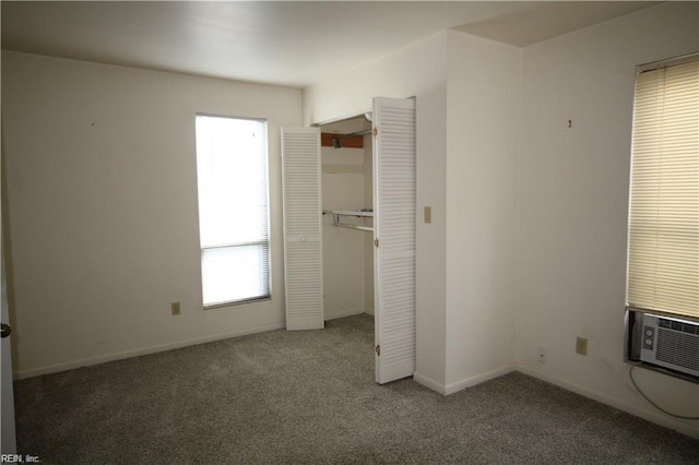 unfurnished bedroom with a closet, cooling unit, and dark colored carpet