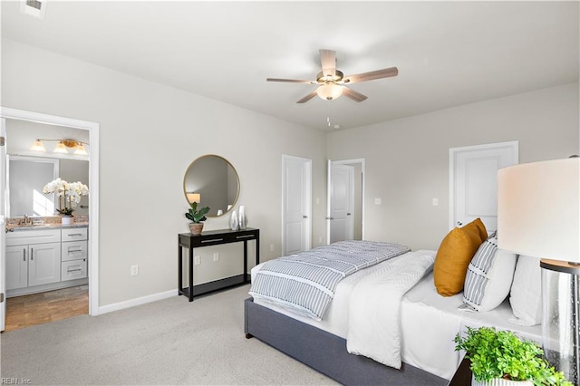 carpeted bedroom with ensuite bathroom, ceiling fan, and sink