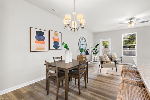 dining space featuring ceiling fan with notable chandelier and dark hardwood / wood-style floors