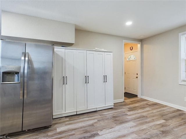 interior space with white cabinets, stainless steel refrigerator with ice dispenser, and light wood-type flooring