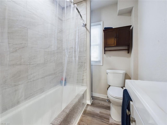 bathroom featuring hardwood / wood-style flooring, tiled shower / bath combo, and toilet