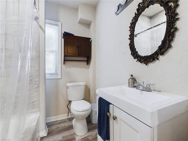 bathroom featuring vanity, hardwood / wood-style flooring, toilet, and plenty of natural light