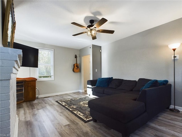 living room featuring ceiling fan and hardwood / wood-style flooring