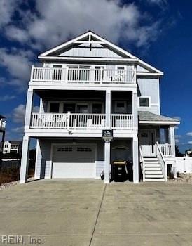 coastal inspired home featuring a balcony and a garage