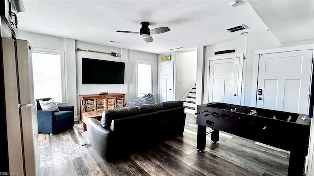 living room with ceiling fan and dark hardwood / wood-style flooring