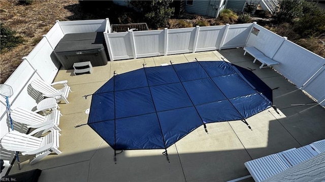 view of swimming pool featuring a patio and a hot tub