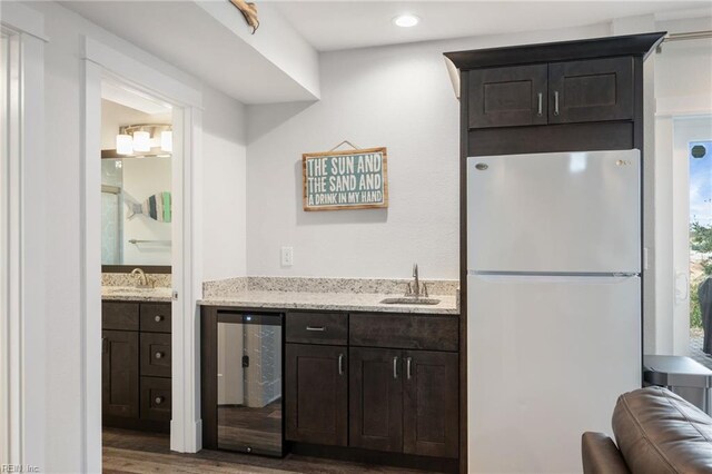 kitchen featuring dark brown cabinets, white fridge, dark hardwood / wood-style floors, and beverage cooler