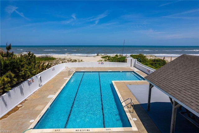 view of swimming pool featuring a water view and a patio