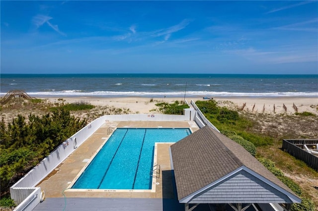 view of pool featuring a water view and a view of the beach