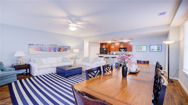 dining room with dark hardwood / wood-style flooring and ceiling fan