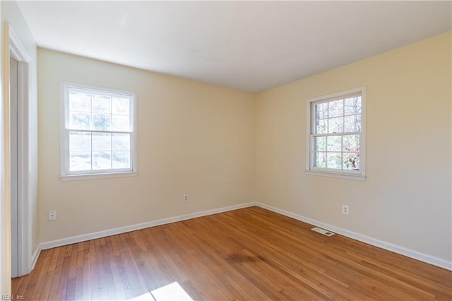 unfurnished room featuring plenty of natural light and hardwood / wood-style floors