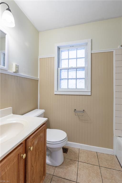 full bathroom featuring wooden walls, tile patterned flooring, vanity, and toilet