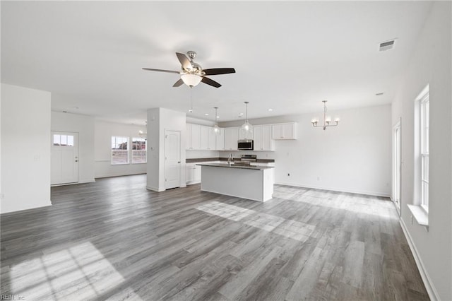 unfurnished living room with light hardwood / wood-style flooring, ceiling fan with notable chandelier, and sink