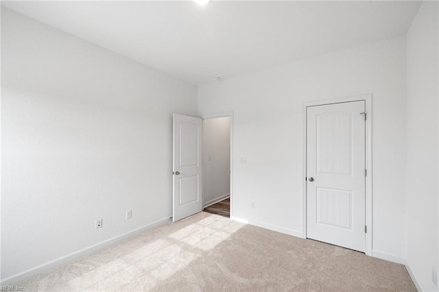 unfurnished room featuring light carpet