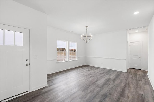 entrance foyer featuring hardwood / wood-style flooring, crown molding, and a chandelier