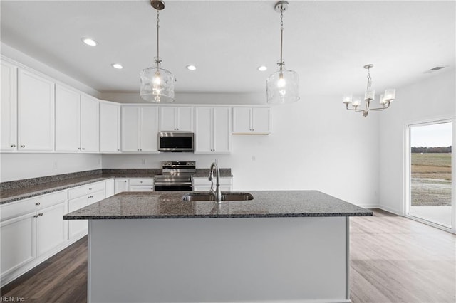 kitchen with a center island with sink, white cabinets, sink, and appliances with stainless steel finishes