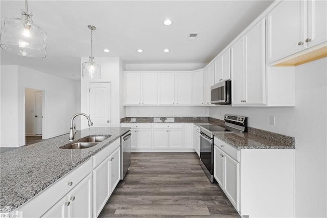 kitchen featuring dark hardwood / wood-style flooring, sink, hanging light fixtures, and appliances with stainless steel finishes