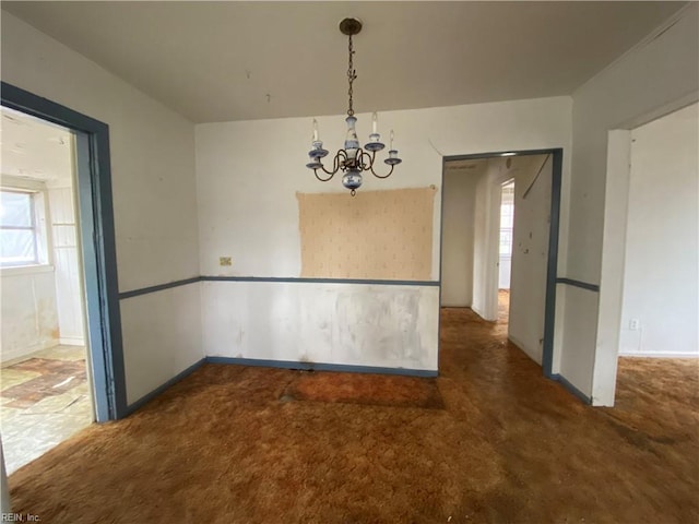 unfurnished dining area featuring dark colored carpet and an inviting chandelier