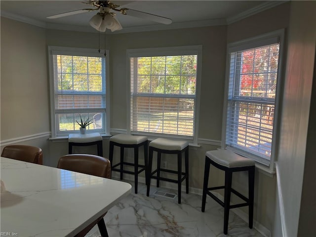 dining area featuring crown molding, ceiling fan, and a healthy amount of sunlight